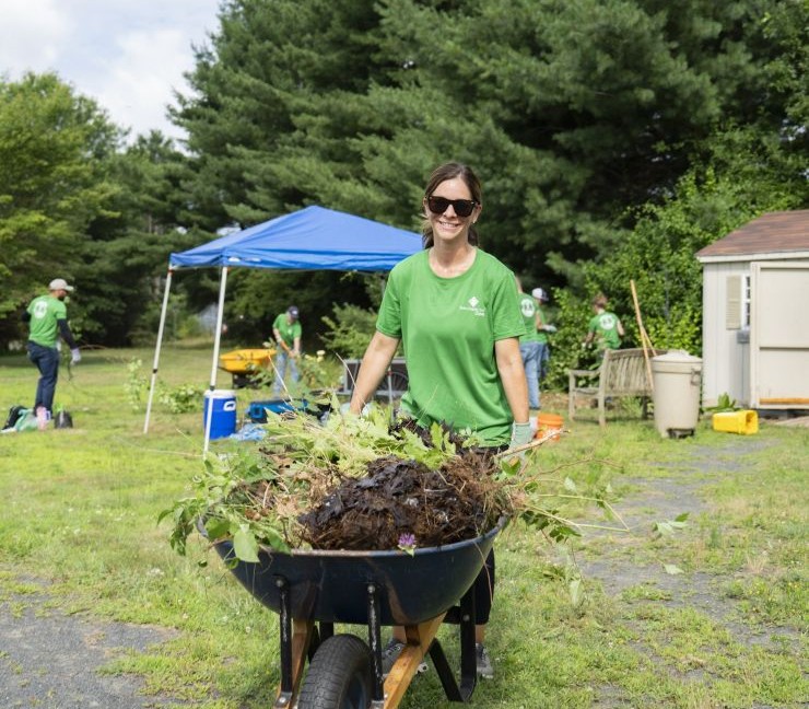 Farm Funders staff member pushing a wheelbarrow and doing community service